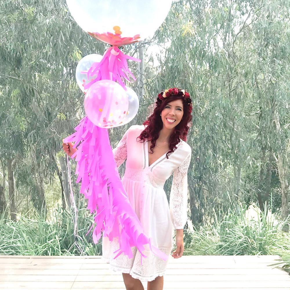 Red haired woman holding purple balloons