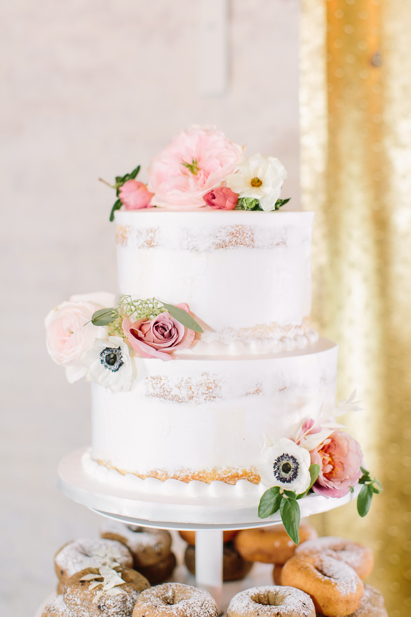White layered wedding cake, edible flowers on top as design