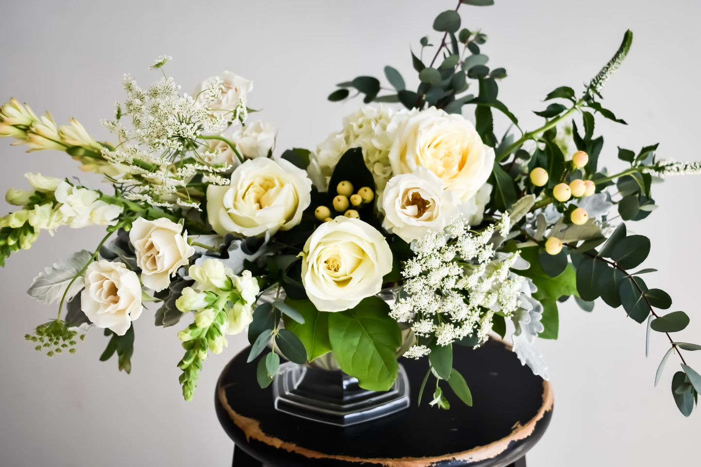 Fancy white roses floral arrangement in clear vase
