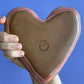 Hand holding Backside of heart shaped ring dish, grey on bottom